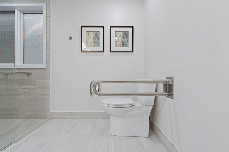 A bright, safe home bathroom with a grab bar beside the shower